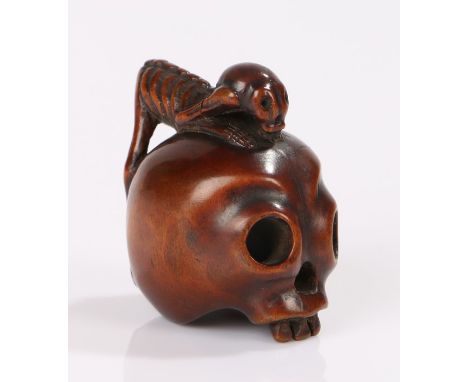 Japanese Meiji period netsuke, the box wood netsuke carved as a skull with a crawling skeleton, 4cm high