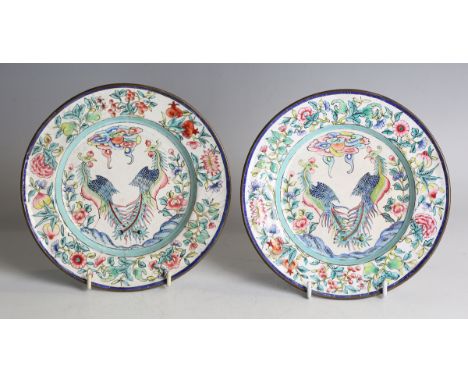 A pair of Chinese Canton export enamel plates, mark of Qianlong but probably later Qing dynasty, each painted with a pair of 