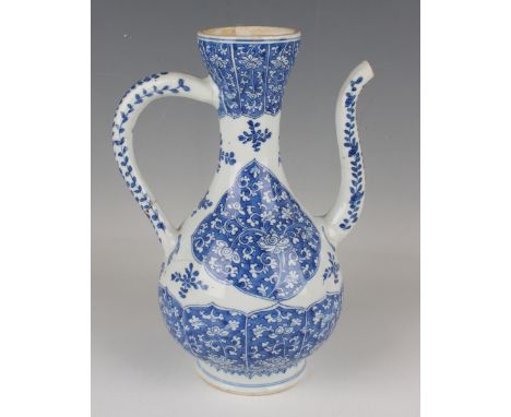 A Chinese blue and white export porcelain ewer, Kangxi period, of Islamic style baluster form, painted with blue ground panel
