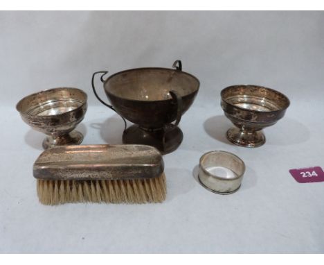 An Edward VII silver three handled cup, Birmingham 1907; a pair of silver bowls, a silver napkin ring and a silver backed bru