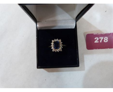 A sapphire and white stone cluster ring. In gold marked 585. 3.4g gross. Size S