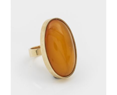 Gelbgold, gest. 585. Zentral besetzt mit honigfarbenem Bernsteincabochon. Gew. ca. 15,99 g. Ring set with honey coloured ambe