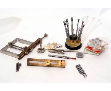 Two boxes of assorted watch sundries including mainsprings and winder and stems, together with a depth tool