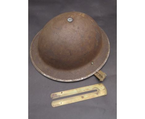 A WWII Brodie pattern Mk.2 helmet with black canvas type oil cloth with rubber pad together with a button stick (2)