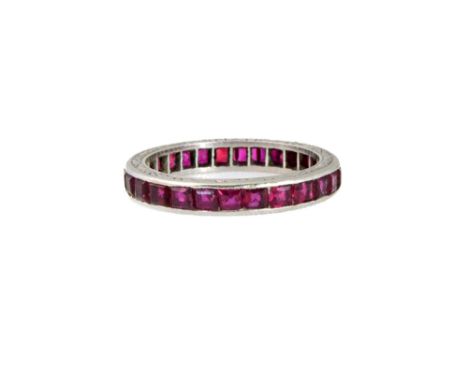 A platinum and ruby set eternity ring with channel set calibre-cut rubies, engraved sides and detailed Plat, size P, 4.4g gro