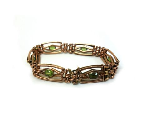 A gold and peridot set gate-link bracelet; set with six oval mixed-cut stones, in mile-grain collets, detailed '9' with safet