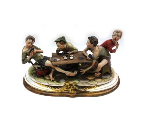 A Capo-di-Monte porcelain sculpture of four boys playing cards, 60cm wide.