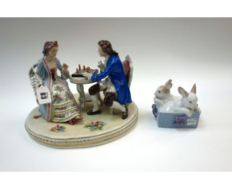 A German porcelain figure group, 20th century, 'The Chess Players', on an oval base,25.5cm wide and a Nao group of two rabbit