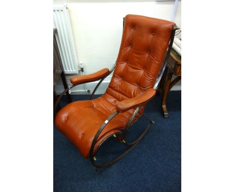 A wrought metal rocking chair, 20th century, button down upholstered in tan leather, stamped 'Phoenix'.