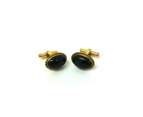 A pair of yellow gold and oval cabochon jade cuff-links, rub over set in rope-twist borders, detailed 14K, 9.8g gross