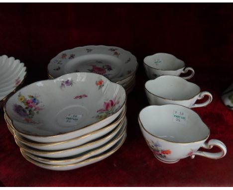 A late Meissen porcelain part tea service painted with flowers and insects including; three cups, five saucers, six tea plate