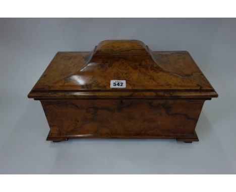 An early Victorian figured walnut sarcophagus tea caddy, the hinged cover enclosing two lidded caddies flanking a mixing bowl