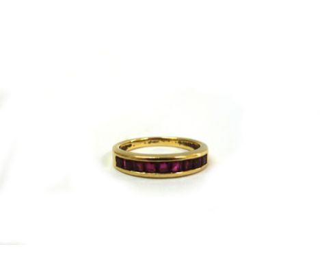 An 18ct yellow gold and ruby set ring, the nine calibre-cut stones in a channel setting, size M, 3.9g gross.