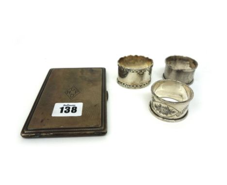 An Art Deco engine turned silver cigarette case, Birmingham 1937, inscribed and three silver napkin rings, varying dates and 