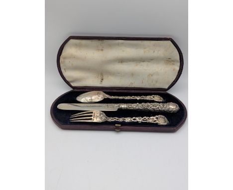 A Victorian silver three piece Christening set comprising of a fork and tablespoon with floral pierced handles, along with a 