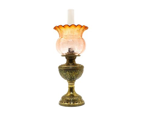 A French brass oil lamp, late 19th century, the urn-shaped body with scrolling foliate repousse decoration, on a pierced circ