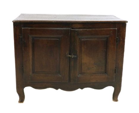 An oak cupboard, 18th century, of joined panelled construction, the ovolo-moulded top above a pair of doors, enclosing shelve