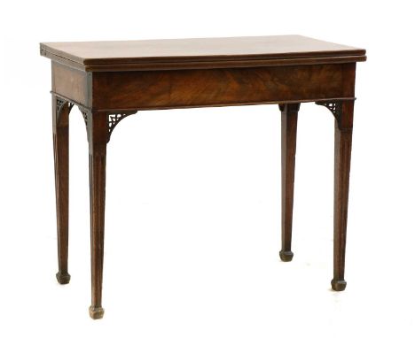 A George III mahogany tea table, rectangular fold-over top to a concertina action, fret carved leg brackets, on tapering squa