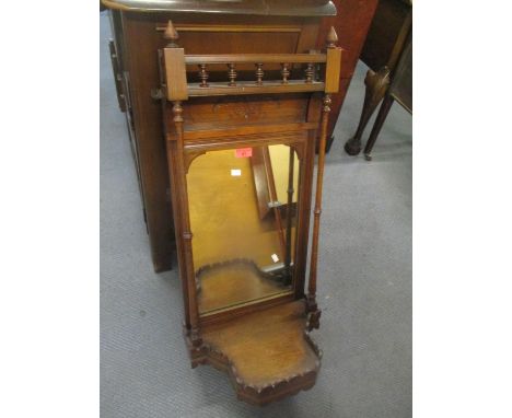 A late Victorian walnut wall hanging mirror having twin columns and shelf below, 34 1/2"h x 14 1/2"w 