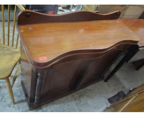 A Victorian mahogany serpentine fronted chiffonier, twin arched fielded cupboard doors flanked by barley twist columns on pli