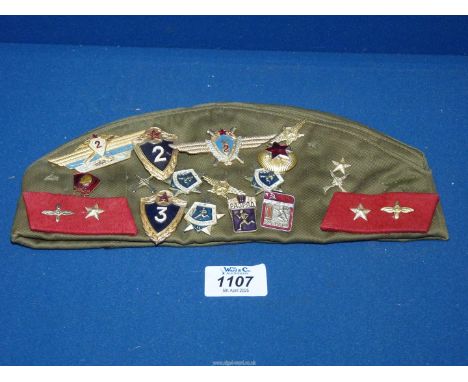 A Russian Army Cap with repro patches and sports awards. 