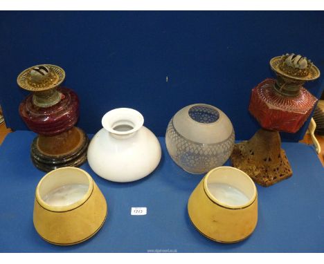 A quantity of glass oil lamp shades and two oil lamp bases with red glass reservoirs , both [a/f]