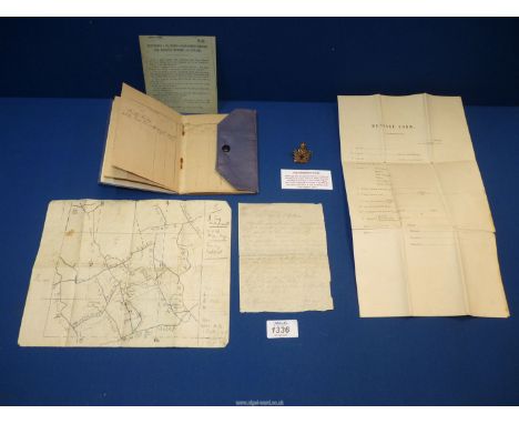 An Intelligence Corps cap badge, a small blue folder containing a service sheet from a member of the East Surrey Regiment, a 