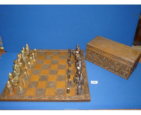 A large Chess set, having wood board and brass pieces, set complete and with carved wooden box.