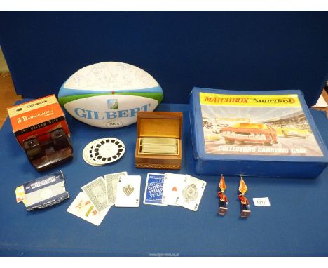 A case of Matchbox toy cars, tankers, lorries etc., a signed 1995 Rugby World Cup souvenir ball, boxed packs of cards and a V