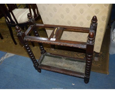 An early 20th century carved stick umbrella stand on four bobbin turned supports, 24" long x 27" tall, with the original drip