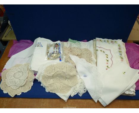 A quantity of linen to include: embroidered table cloth, crochet doilies, a large tablecloth and small pack of loose stamps.