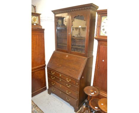 18th Century oak bureau bookcase, the moulded dentil cornice above a pair of glazed doors, the base with a fall front above f