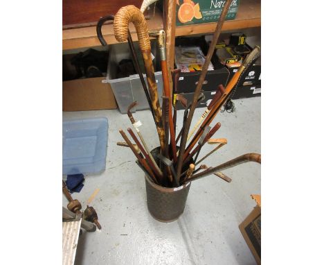 Quantity of various walking canes, riding crops and whips, in a circular copper stick stand