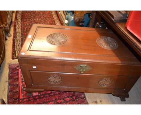 Mid 20th Century Chinese hardwood trunk of rectangular moulded form, the hinged cover relief decorated with roundels, the sin