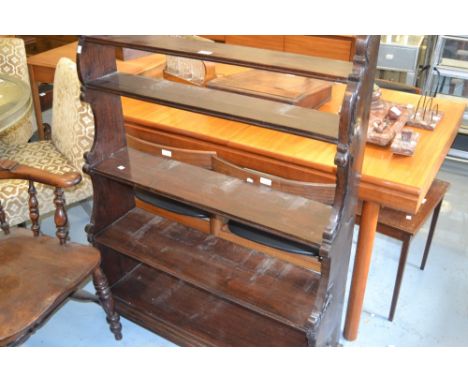 Carved hardwood five shelf waterfall bookcase in Victorian style with a moulded plinth base and turned supports