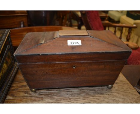 Regency mahogany sarcophagus shaped tea caddy raised on brass ball feet
