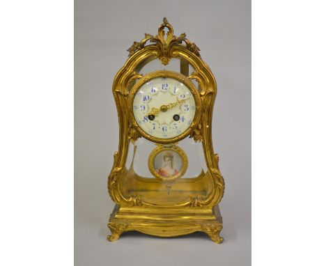 19th Century French gilt brass and bevelled glass mantel clock, the shaped case with floral decoration, the enamel dial with 