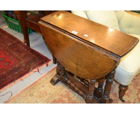 Small reproduction oak oval drop-leaf table in17th Century style, raised on turned supports with bobbin stretchers