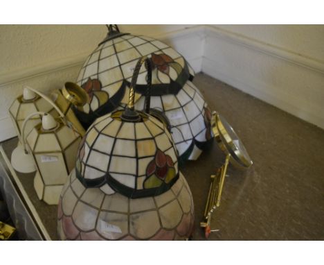 Quantity of various Tiffany style leaded glass lampshades and a similar wall lamp, together with a brass shaving lamp and oth