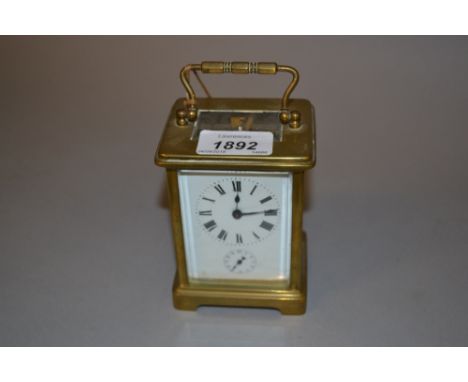 Small brass cased carriage clock, the enamel dial with Roman numerals and subsidiary alarm dial striking on a bell