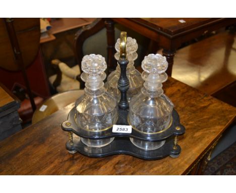 19th Century ebonised and brass mounted three bottle decanter stand with three cut glass decanters and plated labels