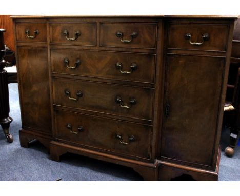 A MAHOGANY BREAKFRONT SIDE CABINET by Harrods, with two short and three long central drawers, flanked by two short drawers an