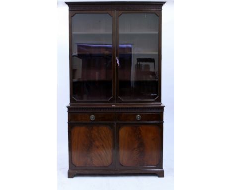 A GEORGIAN STYLE FLAME MAHOGANY GLAZED BOOKCASE  with glazed panelled doors above two fitted frieze drawers and a cupboard, s