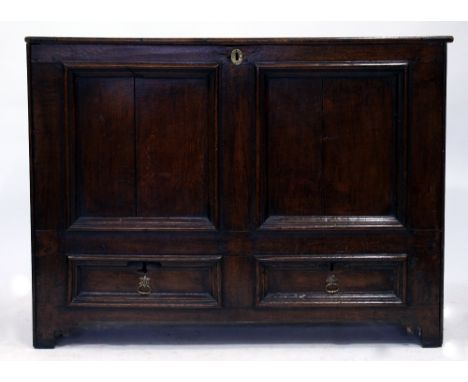A GEORGIAN OAK MULE CHEST with a lifting top, a twin panelled front above two short drawers and bracket feet 124cm wide x 57c