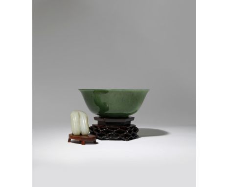 A CHINESE SPINACH-GREEN JADE BOWL AND A PALE CELADON JADE 'BITTER MELON' CARVING 18TH CENTURY The bowl rising from a short fl
