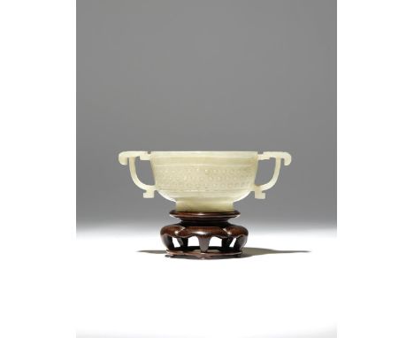 A CHINESE PALE CELADON JADE TWO-HANDLED CUP QING DYNASTY The U-shaped body carved with a band of raised bosses, two sides set