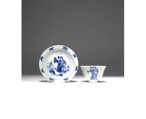 A CHINESE BLUE AND WHITE TEA BOWL AND SAUCER KANGXI 1662-1722 The cup painted with a couple and a lady standing amidst rockwo