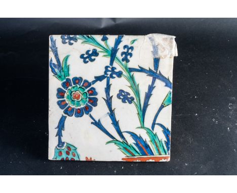 Islamic Art. An Ottoman Iznik tile painted with carnation  Ottoman Turkey, 17th century . damaged on a corner.. Cm 20,00 x 20