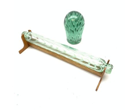 A 19th century Nailsea style glass rolling pin, with wooden display stand, L40cm, together with a Victorian green glass dump 