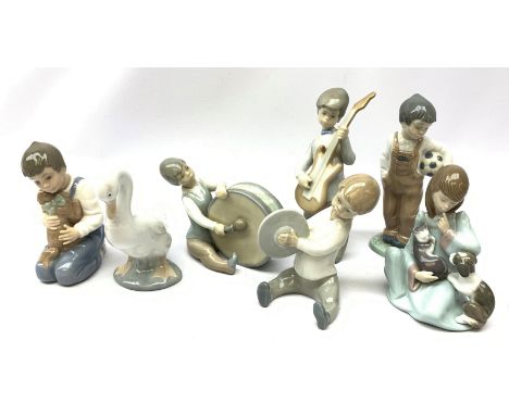  A group of Lladro and Nao figurines, comprising a trio modelled as boys playing instruments, boy with dog, boy with football